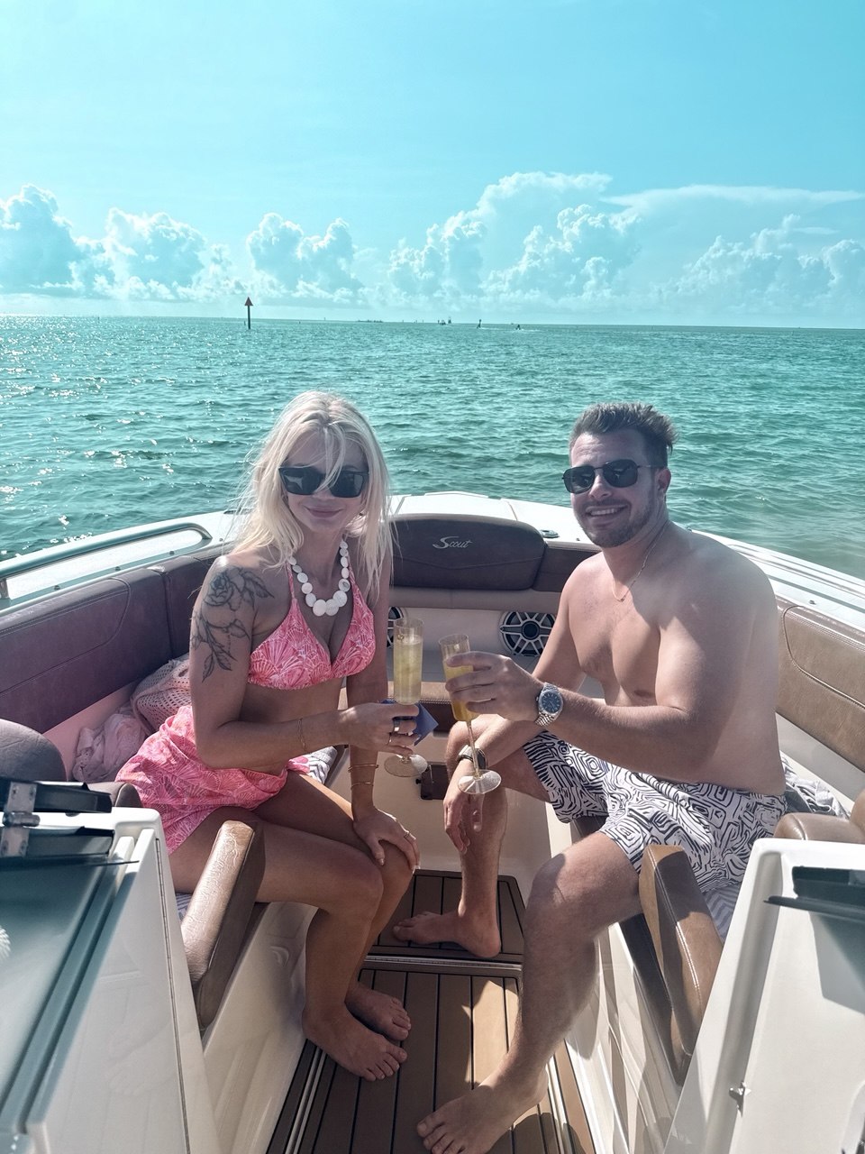 Couple toasting in the bow seating aboard The Bougie Girl on turquoise Islamorada water