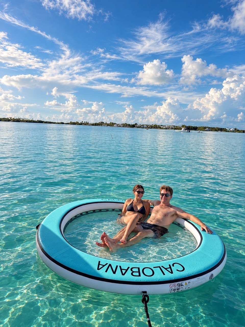 Couple relaxing on a floating lounge in clear Islamorada sandbar water